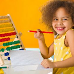 african-american-student-yellow-dress-laughs-brightly-near-abacus-elementary-school-scaled.jpg